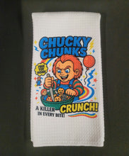 Load image into Gallery viewer, White microfiber kitchen towel with a colorful cartoon Halloween character graphic design  labeled &quot;Chucky Chunks&quot; cereal.